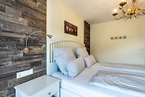 Une chambre à coucher avec un lit, une table de chevet, une lampe et un mur en bois.