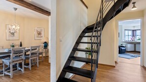 Ein modernes Interieur mit Treppe, Essbereich und Küche.