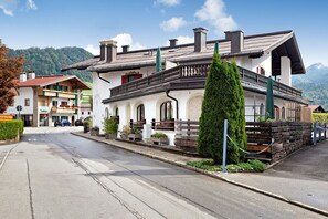 A building with a balcony, a staircase, and a view of the mountains. - 'Apartment Kaisereck Top 2' with Terrace & Wi-Fi (Reit im Winkl)