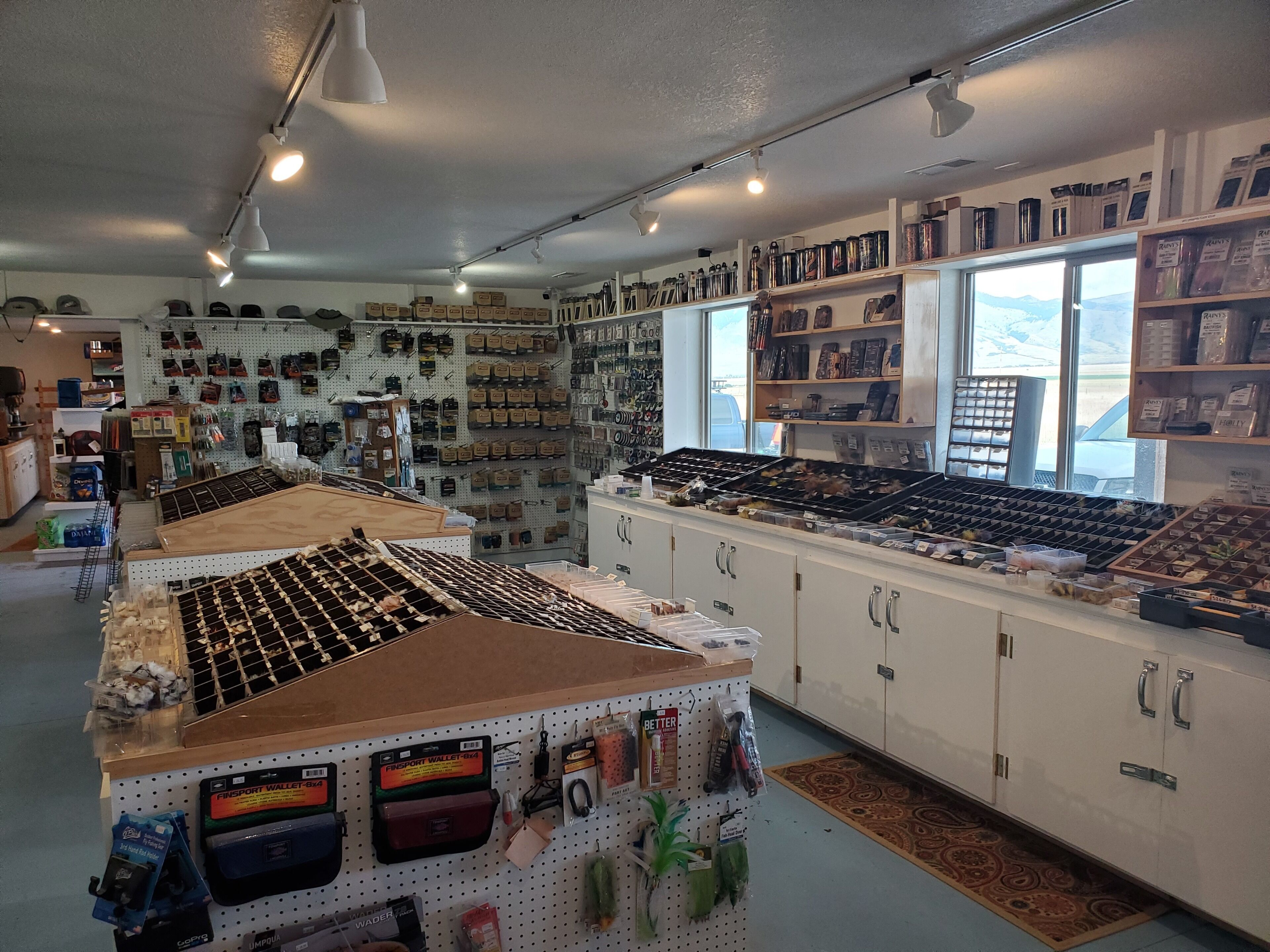 Una tienda minorista con diversos productos en estantes y paneles de exhibición, incluyendo billeteras y accesorios.