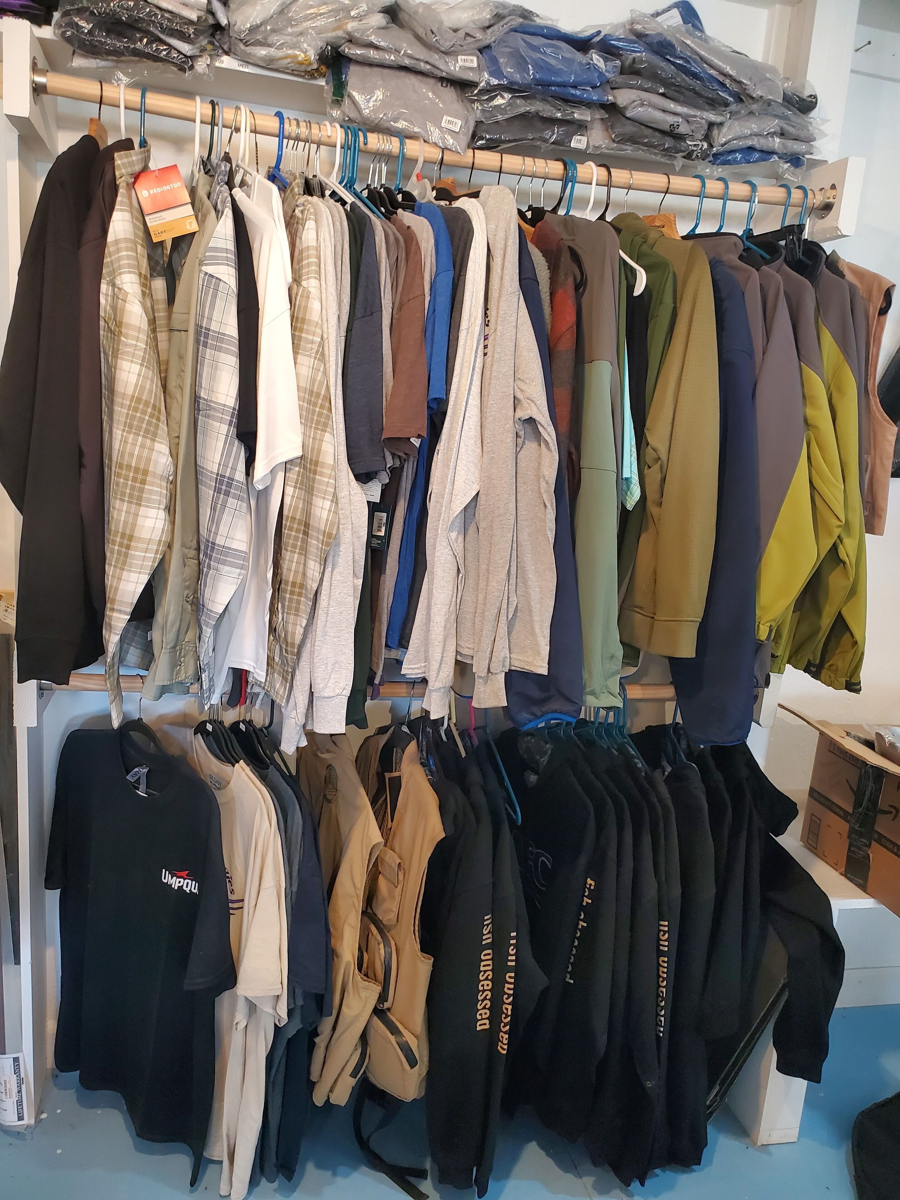 A clothing rack with various garments including shirts, jackets, and pants.