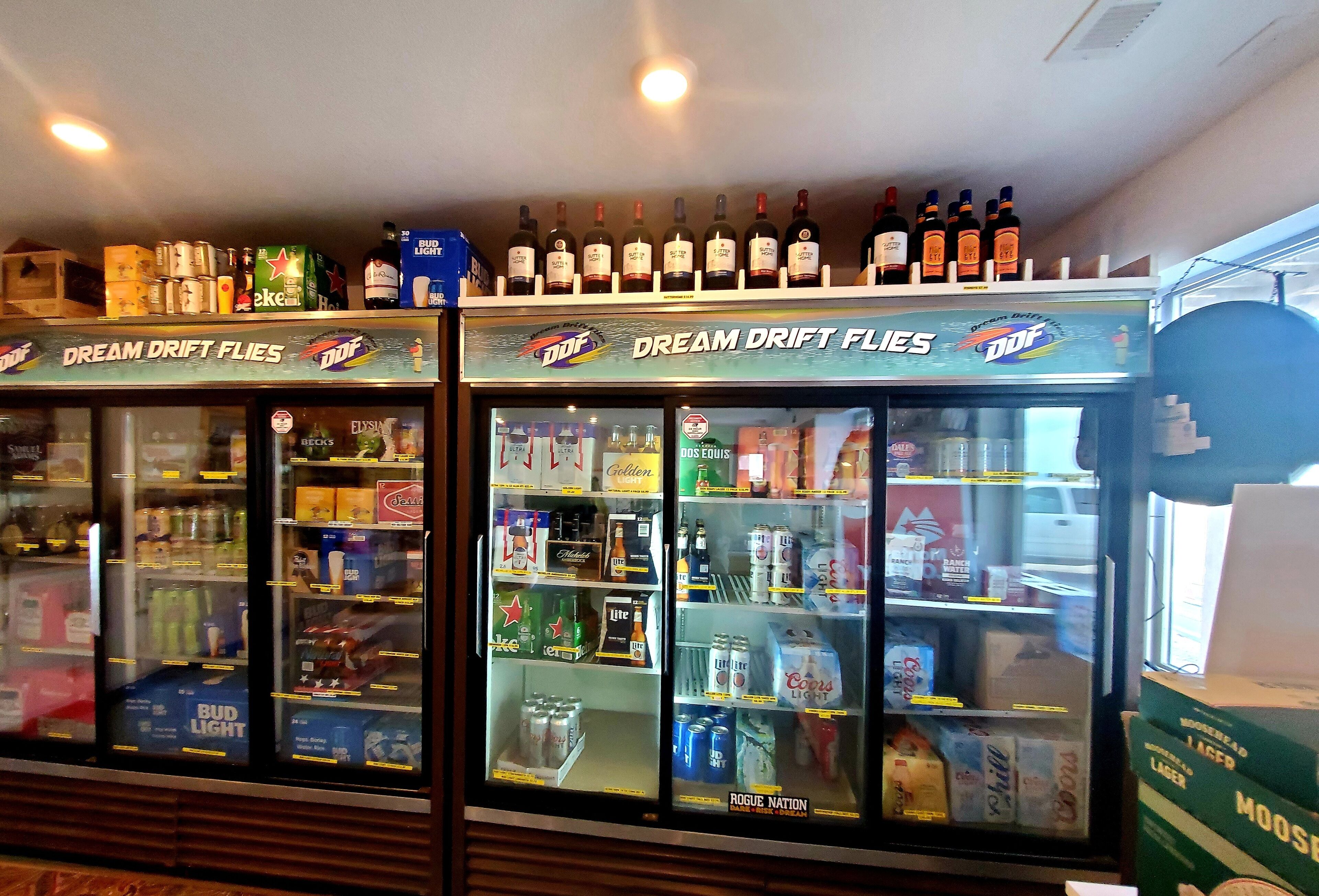 A refrigerated display case with various beers and alcoholic beverages.