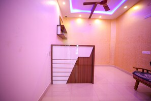 Ein Zimmer mit moderner Treppe, Deckenventilator und Sitzbank.