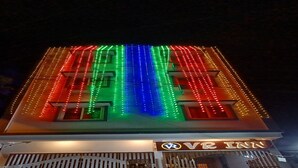 A building with a sign for 'VR INN' and colorful vertical LED lights. - VR Inn (Puducherry)