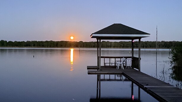 A wooden pier with a gazebo and two chairs extending into a calm lake at sunset. - Lake Fork house with private boat ramp, dock, fishing light, kayak, 8 acres land (Alba)