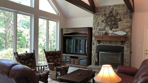 A cozy living room with a fireplace, large windows, and comfortable seating. - Lake Fork house with private boat ramp, dock, fishing light, kayak, 8 acres land (Alba)