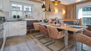 A modern kitchen with a central island, pendant lighting, and a view of the city. - Luxury chalet with sauna and garden (Piesendorf)