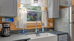 A kitchen with a built-in sink, a coffee maker, and a refrigerator. - Hemlocks Over Muir-WiFi, Firepit, Hot Tub, located in Muir Valley (Rogers)