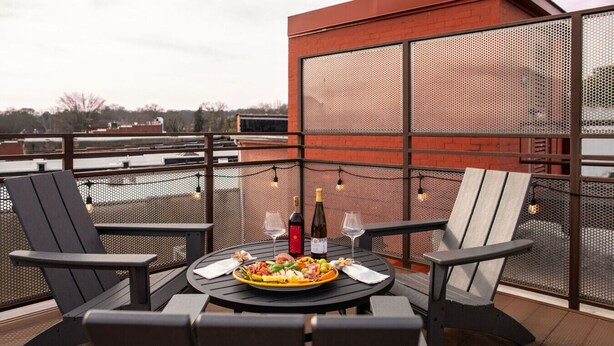 A rooftop dining area with a round table, chairs, and a bottle of wine. - 2 Bedroom Townhouse Downtown Elkin Yadkin Valley (Elkin)