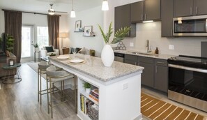 Enjoy cooking in this well-lit kitchen with a central island and bar stools.