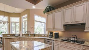 A kitchen with a granite countertop, stainless steel appliances, and beige cabinetry. - 4 Minute Walk to Beach!  Private Pool With Pool Heater.*  Back Deck w/ Lagoon & Golf Course Views! (Hilton Head Island)