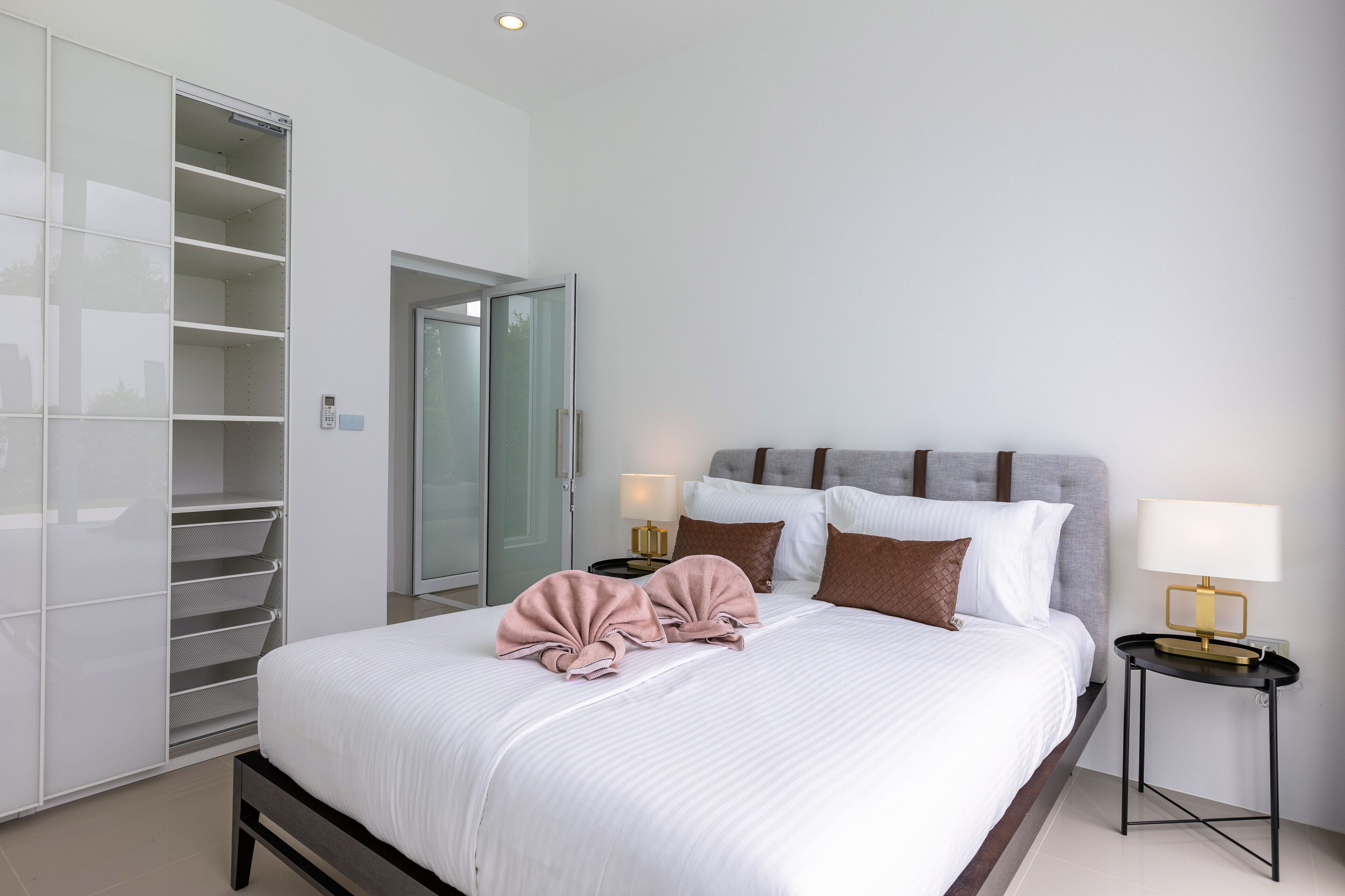 A bedroom with a bed, bedside tables, a wardrobe, and a door to a bathroom.