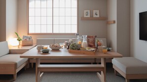 Zona pranzo moderna con tavolo in legno, panche e un'ampia finestra.