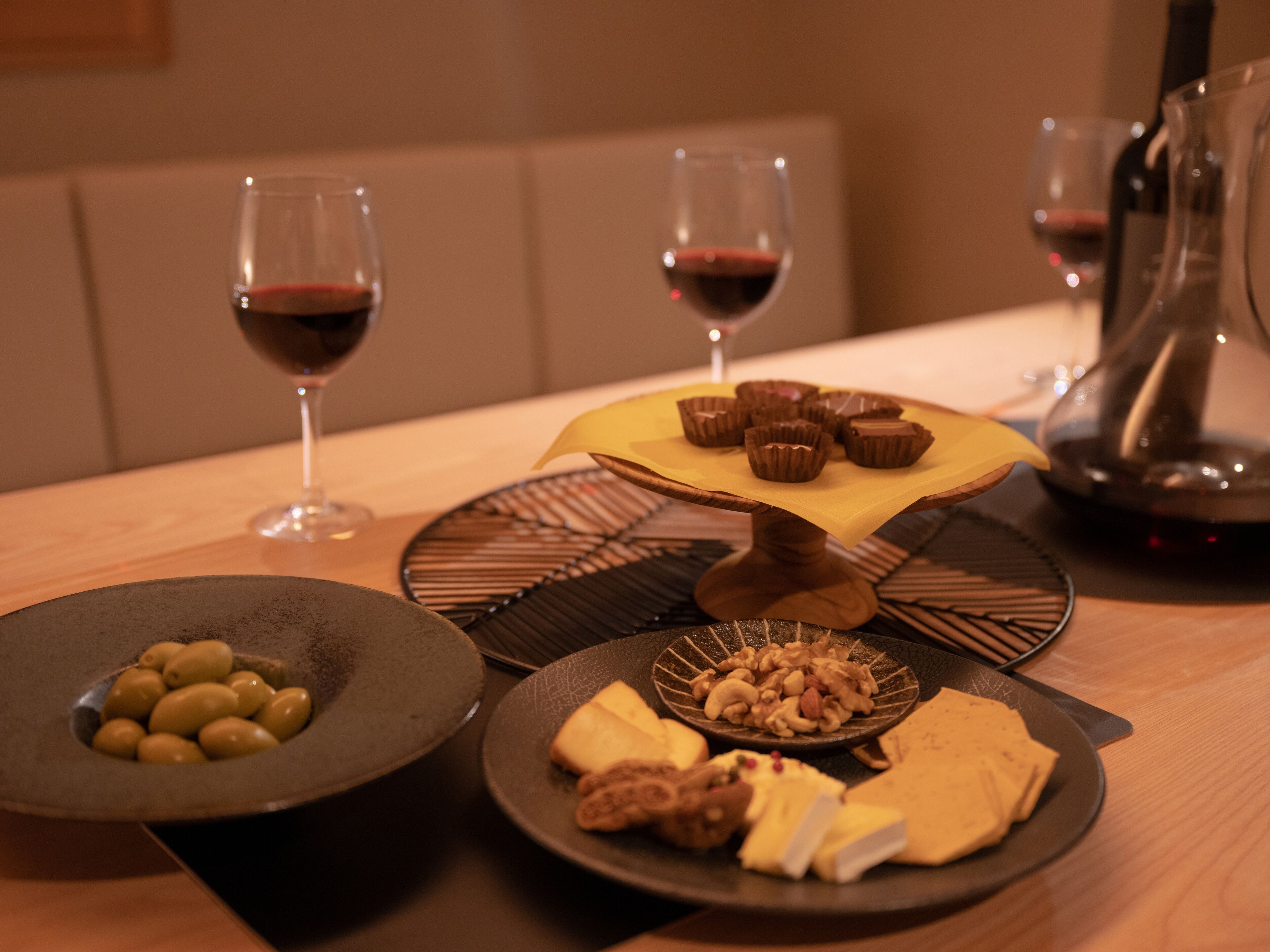 A dining table with various food items and wine glasses.