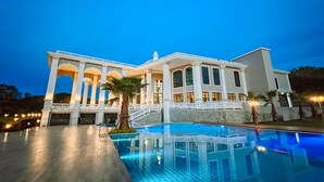 A large, elegant building with a pool and a covered patio area. - Grand Lord Hotel& Residence (Sattahip)