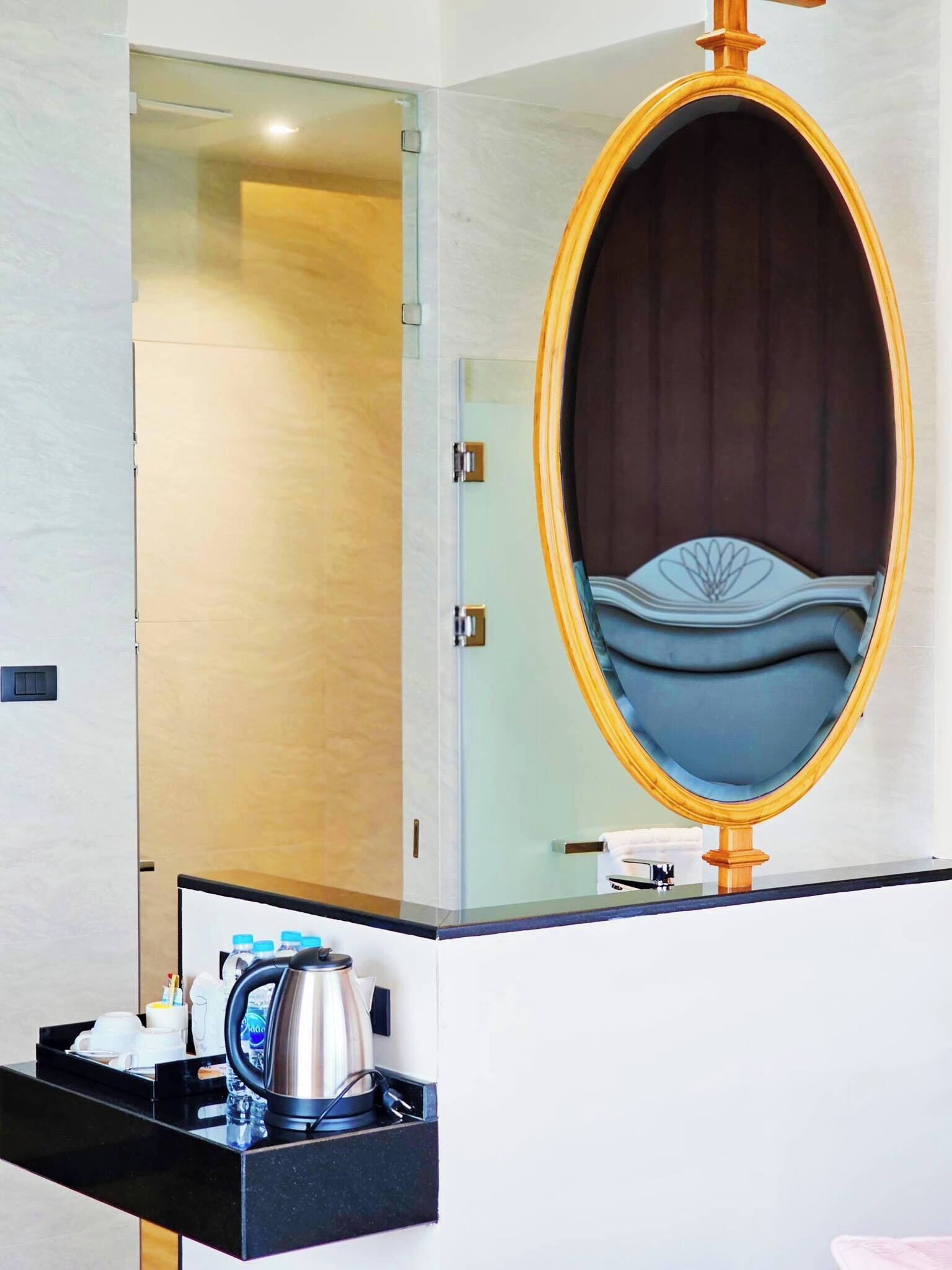 A bathroom with a mirror, a sink, and a coffee maker on the countertop.
