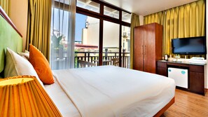 A hotel room with a large bed, a desk with a television, and a view of the city through large windows. - HANZ LakeView Hotel Hanoi (Hanoi)