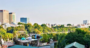 A rooftop terrace with a view of a cityscape, including high-rise buildings and a body of water. - HANZ LakeView Hotel Hanoi (Hanoi)
