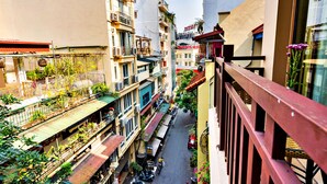 A narrow street flanked by multi-story buildings with balconies, some with plants. - HANZ LakeView Hotel Hanoi (Hanoi)