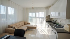 Una cocina moderna con comedor, sofá y vistas al exterior.