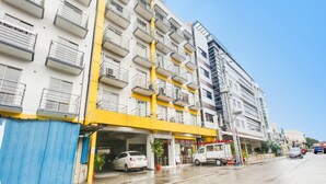 A multi-story building with balconies, a ground-level entrance, and a visible fire truck parked outside. - OYO 893 Dian Suites Makati (Makati)