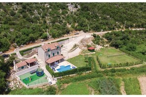 An aerial view of a property with a large house, a swimming pool, a tennis court, and a landscaped garden. - Quiet Village Villa (Desne)