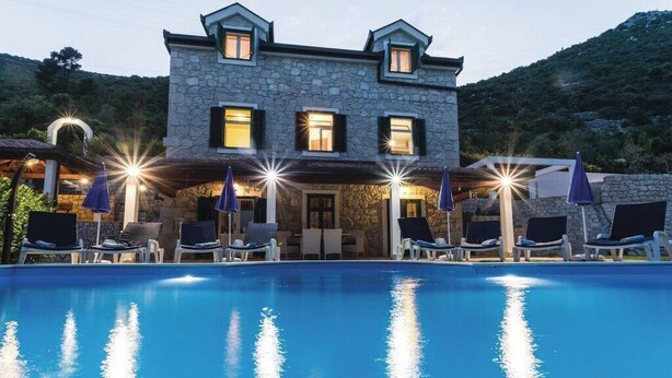 A stone building with a swimming pool, lounge chairs, and umbrellas. - Quiet Village Villa (Desne)