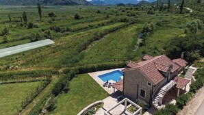 A house with a swimming pool, surrounded by lush greenery and mountains in the background. - Quiet Village Villa (Desne)