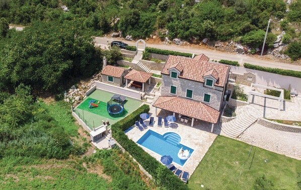 A large house with a swimming pool, outdoor seating, and a tennis court. - Quiet Village Villa (Desne)