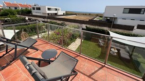 A balcony with a glass railing, a table, and a chair. - Les Dunes 4433 - 60m from the beach, pool and garden (Torroella de Montgri)