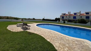 A swimming pool with a stone deck, a grassy area, and a building with a red-tiled roof. - Les Dunes 4433 - 60m from the beach, pool and garden (Torroella de Montgri)