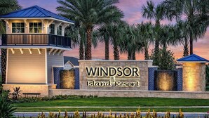 A resort sign with "Windsor Island Resort" written on it, surrounded by palm trees and a well-maintained lawn. - 10BR Resort Villa / Private Pool & Spa / Sleeps 30/ Near Disney (Davenport)