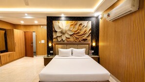 Quarto de hotel moderno com uma cama grande, painéis de madeira, um detalhe decorativo na parede e um aparelho de ar condicionado.