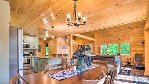 A wooden cabin interior with a dining area, kitchen, and living space. - Peaceful North Haverhill Haven w/ Wood Fire Pit (North Haverhill)