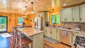 A spacious kitchen with wooden cabinets, granite countertops, and stainless steel appliances. - Peaceful North Haverhill Haven w/ Wood Fire Pit (North Haverhill)