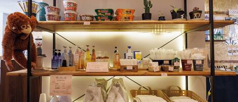 A shelf with various toiletries, a stuffed animal, and some potted plants.