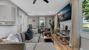 A modern living room with a sofa, coffee table, and dining area.