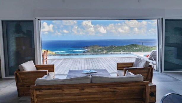 Ein modernes Zimmer mit Holzterrasse, Meerblick und Schwimmbad.