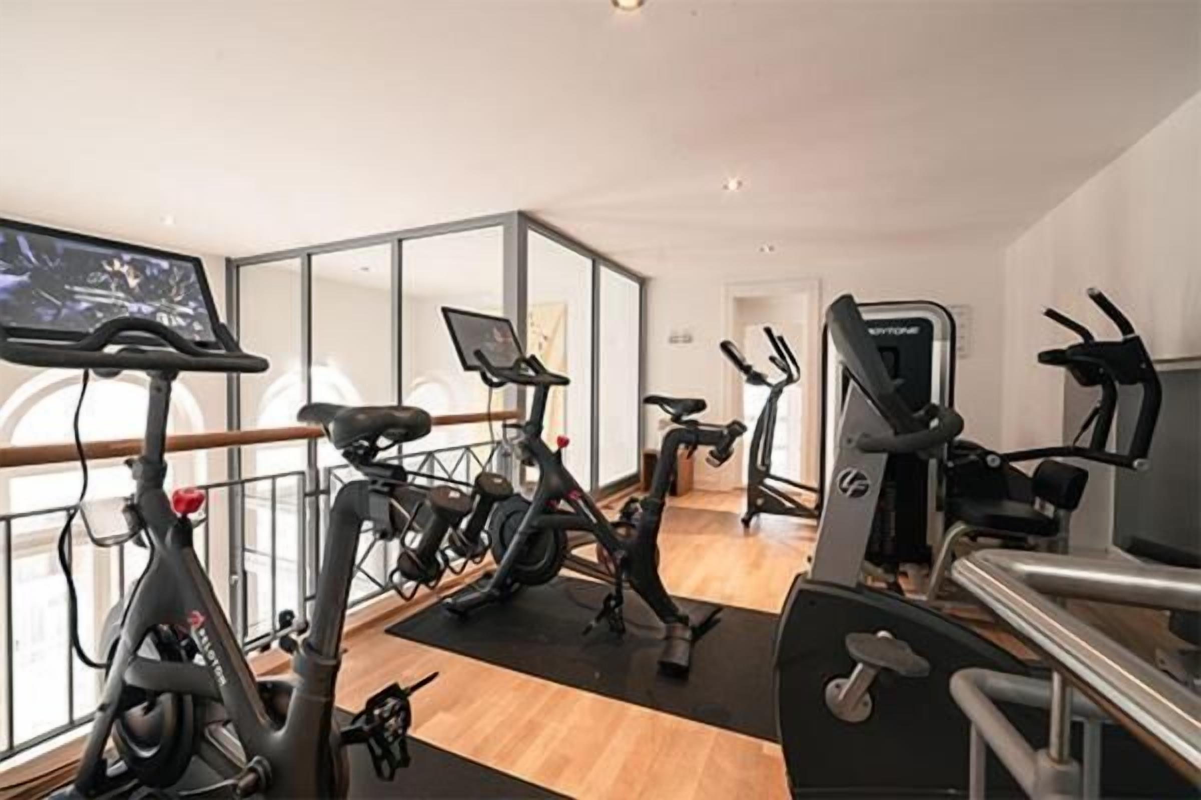 A gym with stationary bikes, treadmills, and a rowing machine.