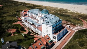 Vista aérea de un hotel grande de varios pisos, con una cúpula destacada y ubicación frente a la playa.