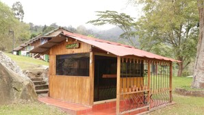 Une cabane en bois avec un toit rouge, une véranda et une enseigne sur laquelle on peut lire « Cabana ».
