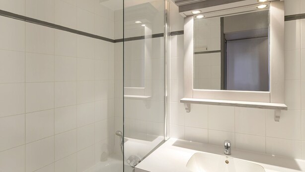 A modern bathroom with a glass shower enclosure, a white sink, and a mirror with a window above it. - Comfy studio, ski-in/ski-out, balcony, Wi-Fi (Belle Plagne)