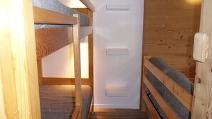 A bunk bed room with wooden walls and a white door. - Comfy studio, ski-in/ski-out, balcony, Wi-Fi (Belle Plagne)