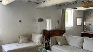 Una sala de estar acogedora con dos sofás, una mesita de centro y una estantería.