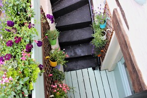 A narrow staircase with black steps and a wooden handrail. - Boutique Fisherman's Grade II Listed Cottage (Scarborough)