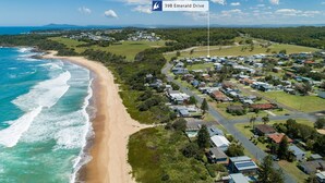 Vista aérea de una zona residencial costera con casas, una playa y una carretera.