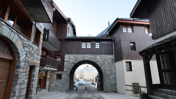 A narrow street with stone buildings and a wooden archway. - Functional apartment in the center with balcony in La Plagne (La Plagne Montchavin Les Coches)