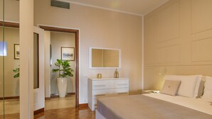 A bedroom with a bed, a dresser, a mirror, and a potted plant. - Ampio appartamento vicino al mare con una grande terrazza solarium. (Alassio)