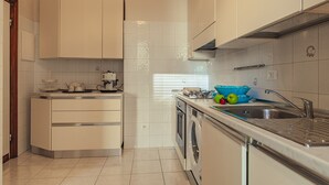 A modern kitchen with white cabinets, a built-in oven, a washing machine, and a sink. - Ampio appartamento vicino al mare con una grande terrazza solarium. (Alassio)