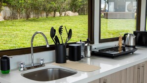 A modern kitchen with a stainless steel sink, a kettle, and a coffee maker on the countertop. - Cozy Loft with big terras having a spectaculair view of San Jose (San Antonio de Escazú)